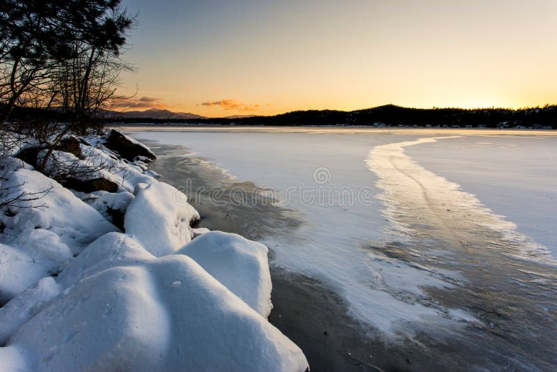 The snow covered rocky shoreline of Hauser Lake in Idaho at sunset. The snow covered rocky shoreline of Hauser Lake in Idaho at sunset.