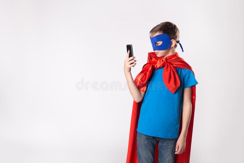 Παιδί Superhero που χρησιμοποιεί το κινητό τηλέφωνο στοκ φωτογραφία με δικαίωμα ελεύθερης χρήσης Παιδί Superhero που χρησιμοποιεί το κινητό τηλέφωνο στοκ φωτογραφία με δικαίωμα ελεύθερης χρήσης