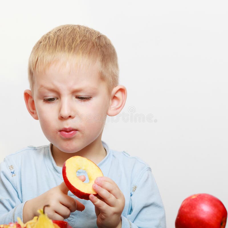 Παιδί παιδιών αγοριών preschooler με το τέμνον μήλο φρούτων μαχαιριών στο σπίτι στοκ εικόνα Παιδί παιδιών αγοριών preschooler με το τέμνον μήλο φρούτων μαχαιριών στο σπίτι στοκ εικόνα