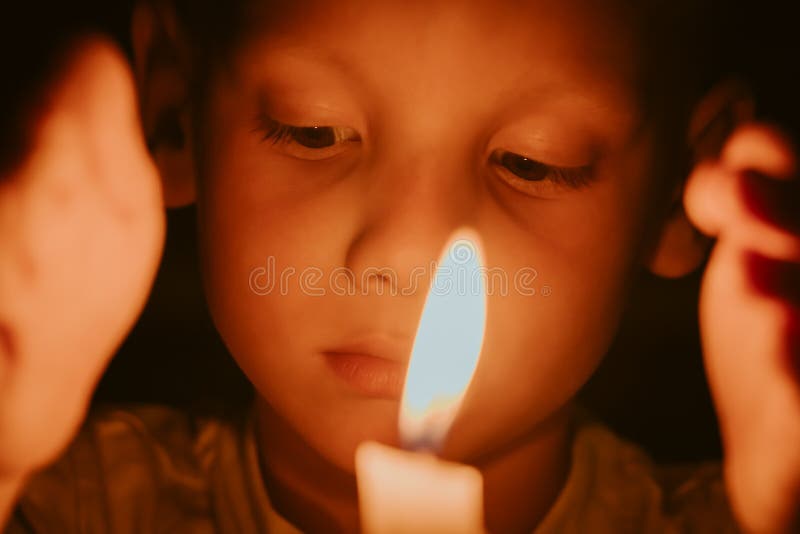 παιδί με θλιμμένα μάτια κοιτάζει τη φλόγα που καίει το κερί στο σκοτάδι. μνήμες ή πένθος για νεκρούς. θρησκευτικό ιερό στην εκκλησ διανυσματική απεικόνιση
