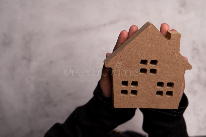 Child hand man holding a wooden model house. Concept of love family and security protection, Trust for construction and home renovation. Child hand man holding a wooden model house. Concept of love family and security protection, Trust for construction and home renovation