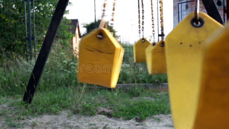 παιδιά κίτρινη κενή κούνια σε αλυσίδες στην αυλή