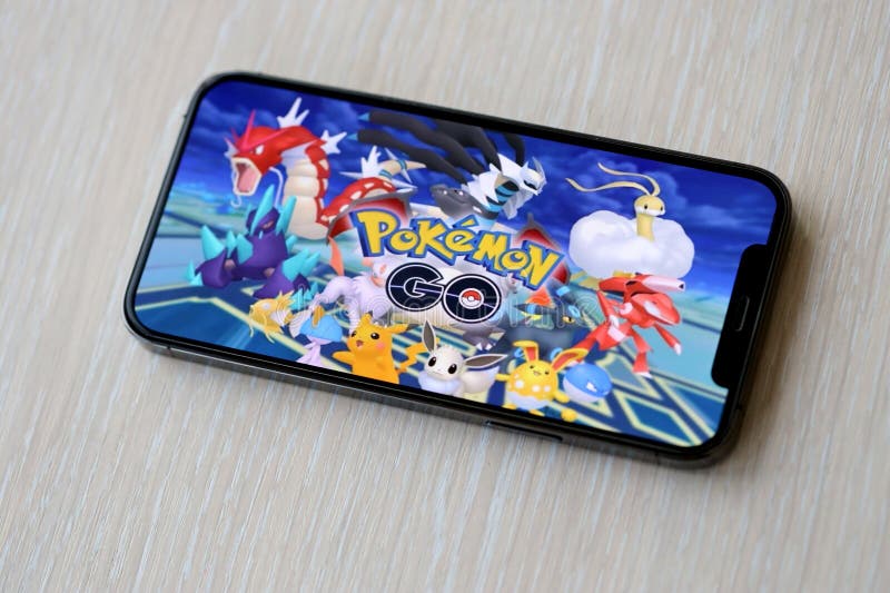 Pokemon GO mobile iOS game on iPhone 15 smartphone screen on wooden table during mobile gameplay. Mobile gaming and entertainment on portable device. Pokemon GO mobile iOS game on iPhone 15 smartphone screen on wooden table during mobile gameplay. Mobile gaming and entertainment on portable device