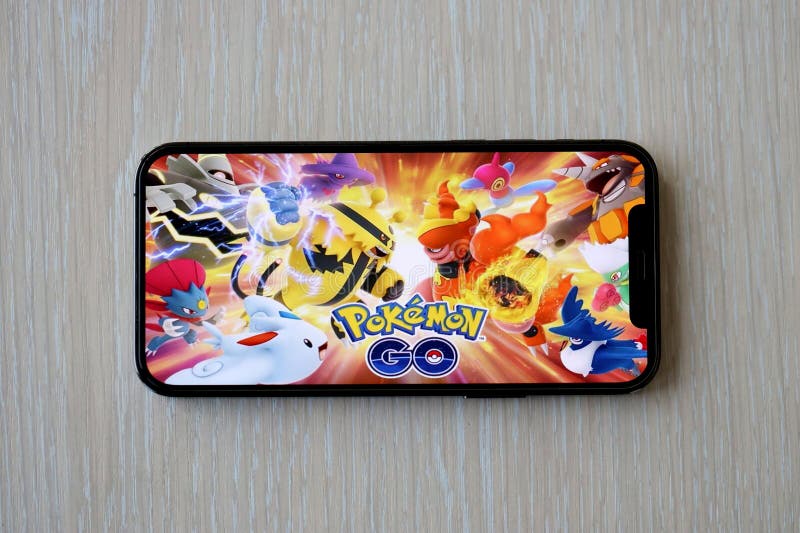 Pokemon GO mobile iOS game on iPhone 15 smartphone screen on wooden table during mobile gameplay. Mobile gaming and entertainment on portable device. Pokemon GO mobile iOS game on iPhone 15 smartphone screen on wooden table during mobile gameplay. Mobile gaming and entertainment on portable device