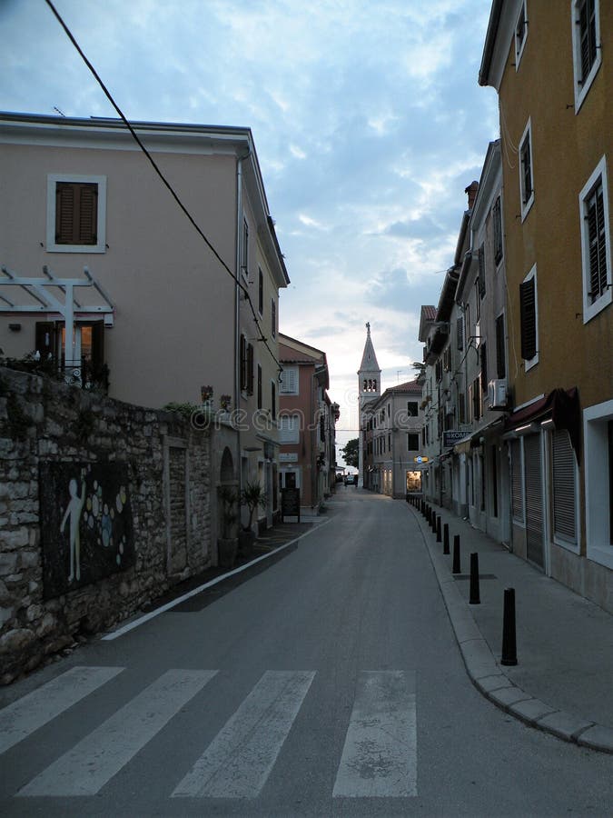 Παλαιά πόλη Istrian Novigrad, Κροατία Μια όμορφη εκκλησία με έναν υψηλό κομψό πύργο κουδουνιών, αλέες πετρών και ένα παλαιό μεσογ στοκ εικόνες