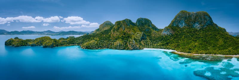 Πανοραμική άποψη του ακατοίκητου τροπικού νησιού με άγρια βουνά, ζούγκλα τροπικών δασών, αμμώδεις παραλίες