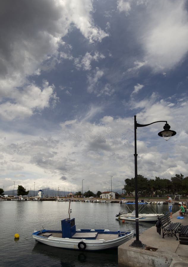 Πανοραμική άποψη του αλιευτικού σκάφους σε ένα ηλιόλουστο απόγευμα στο ήρεμο Αιγαίο πέλαγος στην προκυμαία της πόλης παραλιών Nea στοκ φωτογραφίες Πανοραμική άποψη του αλιευτικού σκάφους σε ένα ηλιόλουστο απόγευμα στο ήρεμο Αιγαίο πέλαγος στην προκυμαία της πόλης παραλιών Nea στοκ φωτογραφίες
