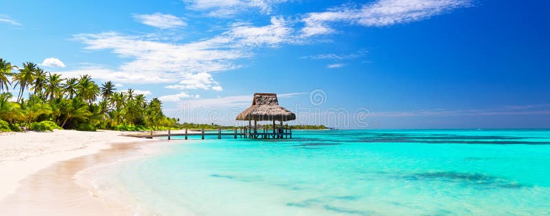 Panorama of beautiful gazebo on the tropical white sandy beach in Punta Cana, Dominican Republic. Vacation holidays summer background. View of nice tropical beach. Panorama of beautiful gazebo on the tropical white sandy beach in Punta Cana, Dominican Republic. Vacation holidays summer background. View of nice tropical beach