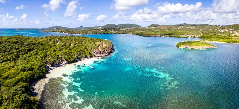 Paradise beach and bay in Carribean archipelago in Antilles with transparent turquoise sea water and coral reefs. Aerial drone panorama of coast white sand and green forest, summer holidays vacation. Paradise beach and bay in Carribean archipelago in Antilles with transparent turquoise sea water and coral reefs. Aerial drone panorama of coast white sand and green forest, summer holidays vacation