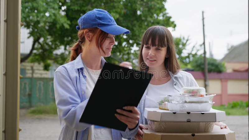 παράδοση σε καταστήματα χαμογελαστών γυναικών ταχυδρόμος φέρνει ψώνια σε νέες παραγγελίες πελατών στο καφέ σε σπίτι απόθεμα βίντεο