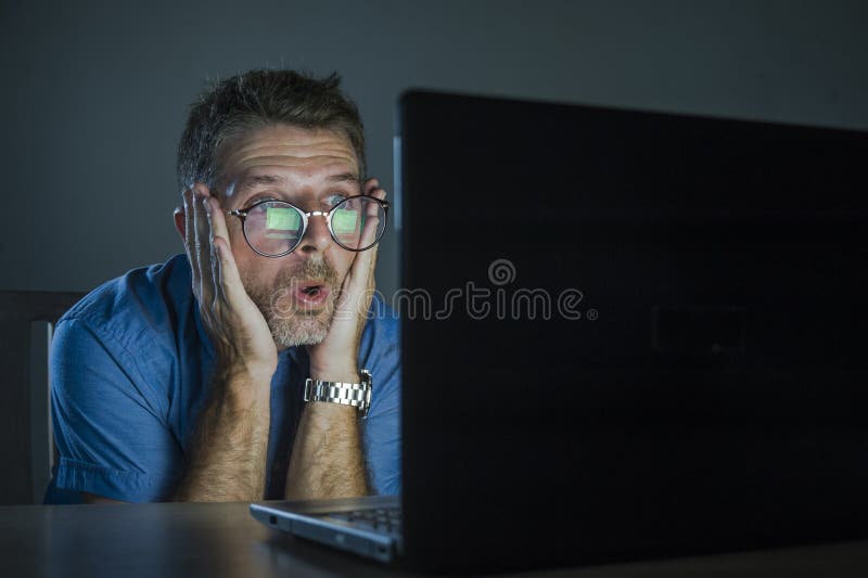 Παράξενο συγκλονισμένο και έκπληκτο geek επανδρώνουν στα γυαλιά nerd που λειτουργούν στο φορητό προσωπικό υπολογιστή αργά - νύχτα στοκ εικόνες με δικαίωμα ελεύθερης χρήσης Παράξενο συγκλονισμένο και έκπληκτο geek επανδρώνουν στα γυαλιά nerd που λειτουργούν στο φορητό προσωπικό υπολογιστή αργά - νύχτα στοκ εικόνες με δικαίωμα ελεύθερης χρήσης