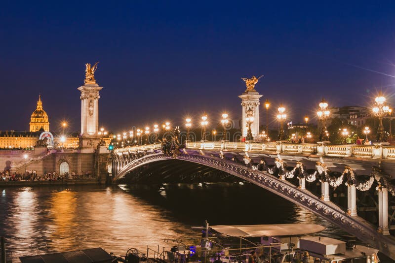 Paris by night, beautiful illumination of Alexandre III bridge on Seine river in the evening, historical architecture. Paris by night, beautiful illumination of Alexandre III bridge on Seine river in the evening, historical architecture