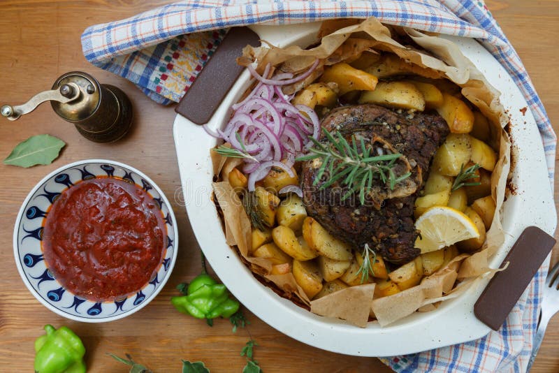 Traditional Greek kleftiko, an oven-baked lamb stew with mizithra cheese, olive oil, onion, carrot, garlic and herbs, served with lemon roast potatoes. Traditional Greek kleftiko, an oven-baked lamb stew with mizithra cheese, olive oil, onion, carrot, garlic and herbs, served with lemon roast potatoes.