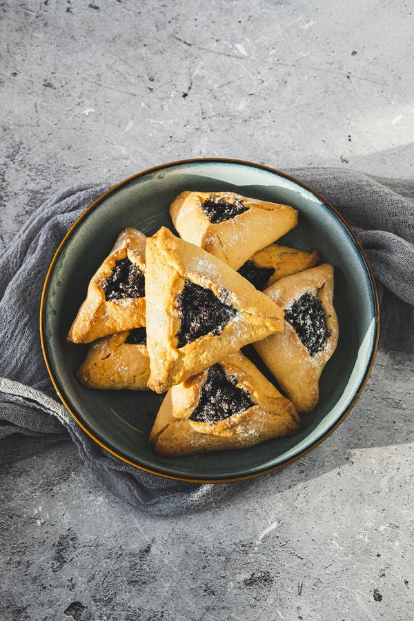 Παραδοσιακά μπισκότα Hamantaschen με σπόρους παπαρούνας στην γκρι επιφάνεια. Ιδέα εορτασμού του Purim στοκ εικόνες με δικαίωμα ελεύθερης χρήσης