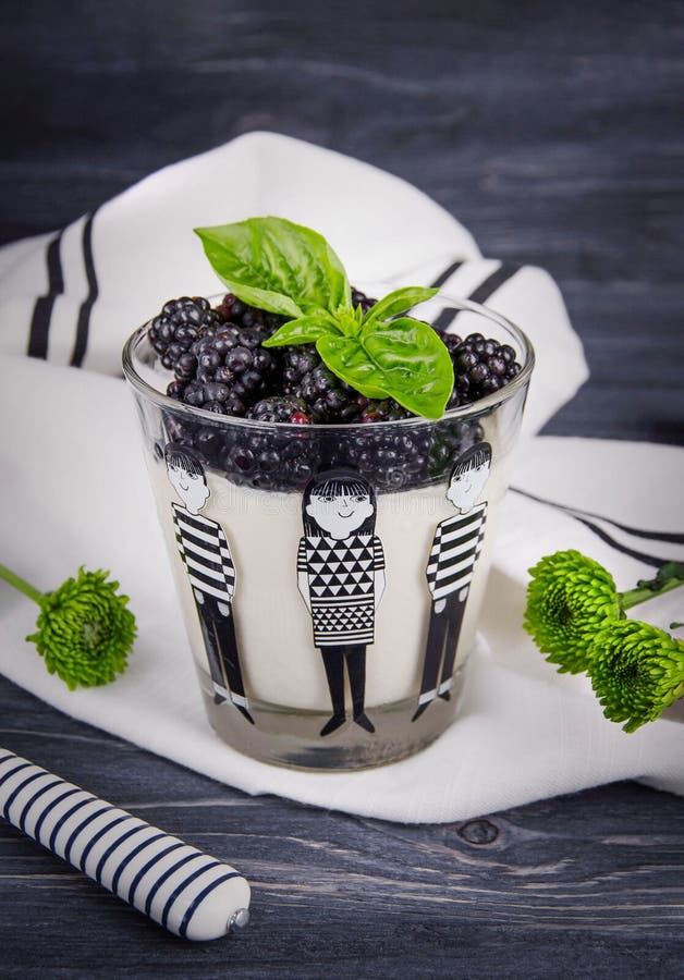 παραδοσιακό ιταλικό γλυκό panna cotta με φρέσκα βατόμουρα και πράσινο βασιλικό σε σκούρο ξύλινο φόντο στοκ φωτογραφία με δικαίωμα ελεύθερης χρήσης