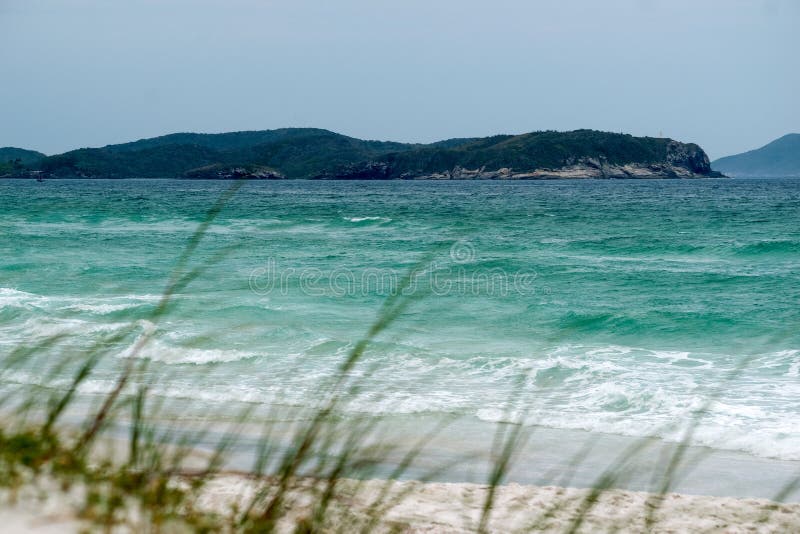 παραλία της praia das dunas με τις όμορφες θαλάσσιες λευκές αμμώδεις θίνες και πολλά βουνά στο φόντο. στοκ φωτογραφίες