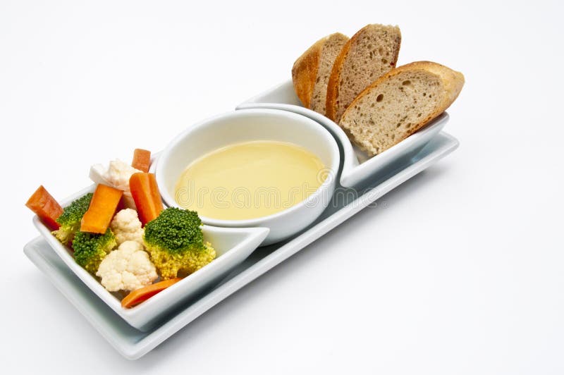 White shaped dishes with vegetables, bread and olive oil on a white background. White shaped dishes with vegetables, bread and olive oil on a white background