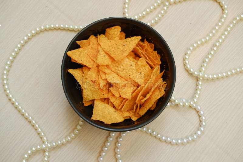 Tortilla chips in a bowl with pearls on the table. this photo looks good. Tortilla chips in a bowl with pearls on the table. this photo looks good
