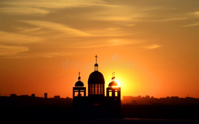 Silhouette of the church building at sunset. Beautiful red sunset with black silhouette of a church building. The sun shines through the window. Silhouette of the church building at sunset. Beautiful red sunset with black silhouette of a church building. The sun shines through the window.