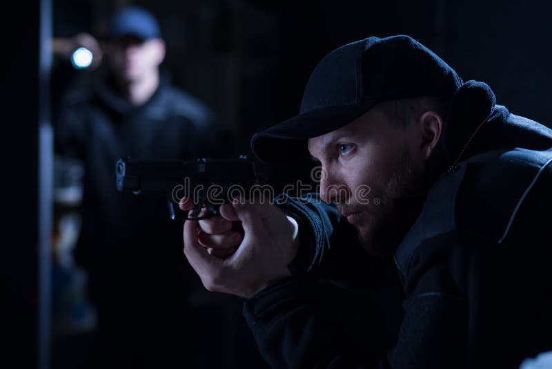 Police officer holding handgun during police intervention. Police officer holding handgun during police intervention