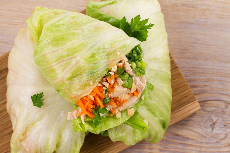 Lettuce wraps with chicken, carrot, peanuts and ginger-scallion oil. View from above, top, horizontal. Lettuce wraps with chicken, carrot, peanuts and ginger-scallion oil. View from above, top, horizontal