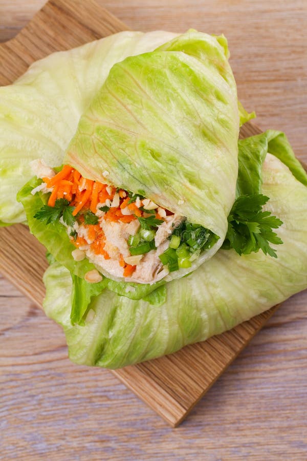 Lettuce wraps with chicken, carrot, peanuts and ginger-scallion oil. View from above, top, vertical. Lettuce wraps with chicken, carrot, peanuts and ginger-scallion oil. View from above, top, vertical