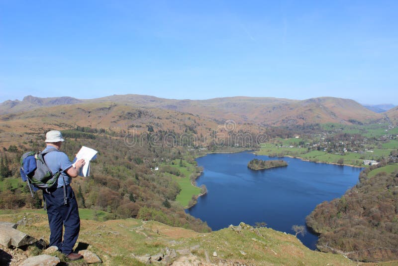 Περιπατητής με το χάρτη που κοιτάζει σε Grasmere, περιοχή λιμνών στοκ εικόνες Περιπατητής με το χάρτη που κοιτάζει σε Grasmere, περιοχή λιμνών στοκ εικόνες