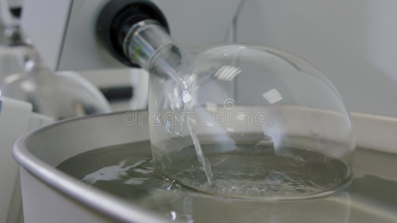 περιστροφικός εξατμιστής κενού σε χημικό εργαστήριο. γυάλινος βολβός περιστρέφεται σε υγρό.