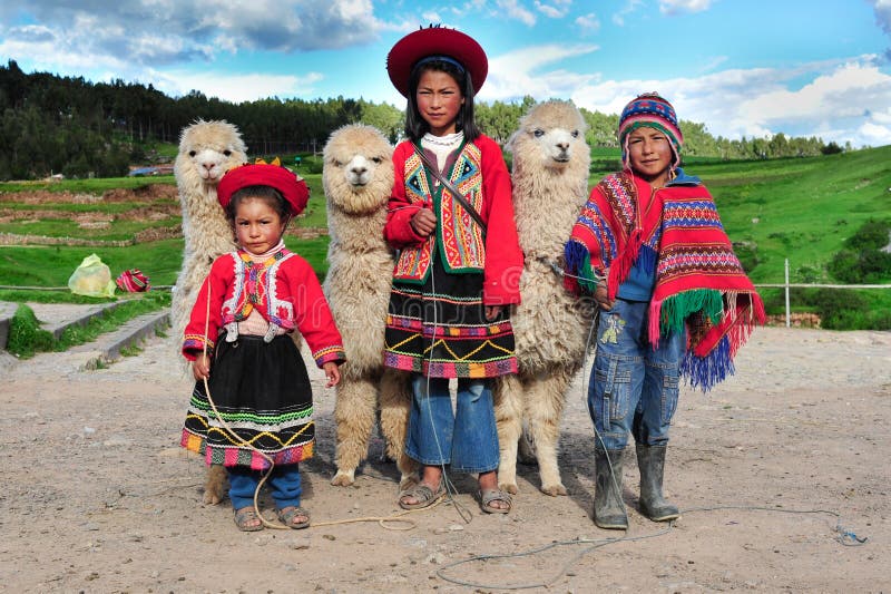 2010-03-08 - Sacsayhuaman, Cusco, Peru: Peruvian children in traditional dresses standing in row with small Alpacas. 2010-03-08 - Sacsayhuaman, Cusco, Peru: Peruvian children in traditional dresses standing in row with small Alpacas.