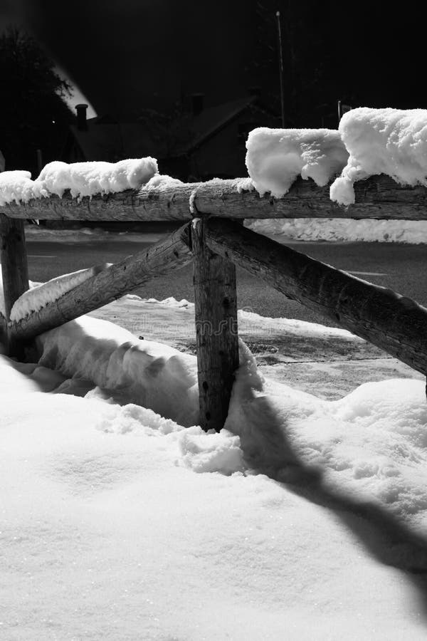 Πεσμένο Wintertime χιόνι στο ξύλινο μοτίβο φρακτών τη νύχτα με τον καπνό που βγαίνει η καπνοδόχος με το πίσω φως στοκ εικόνα με δικαίωμα ελεύθερης χρήσης Πεσμένο Wintertime χιόνι στο ξύλινο μοτίβο φρακτών τη νύχτα με τον καπνό που βγαίνει η καπνοδόχος με το πίσω φως στοκ εικόνα με δικαίωμα ελεύθερης χρήσης
