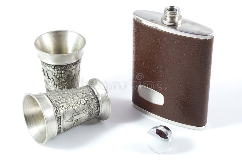 A hip flask and small pewter cups. A scene evoking an image of a hunting or walking expedition. An image to evoke a scene of country sports and the aristocratic, landed gentry lifestyle. On white background. A hip flask and small pewter cups. A scene evoking an image of a hunting or walking expedition. An image to evoke a scene of country sports and the aristocratic, landed gentry lifestyle. On white background.