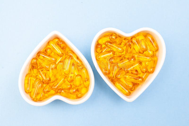 Πιάτο καρδιά-μορφής με τις κάψες Omega 3, υγιές προϊόν και στενός επάνω πετρελαίου ψαριών έννοιας συμπληρωμάτων, στοκ φωτογραφία με δικαίωμα ελεύθερης χρήσης Πιάτο καρδιά-μορφής με τις κάψες Omega 3, υγιές προϊόν και στενός επάνω πετρελαίου ψαριών έννοιας συμπληρωμάτων, στοκ φωτογραφία με δικαίωμα ελεύθερης χρήσης
