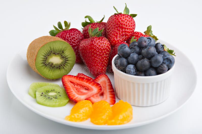 A plate of colorful, delicious fruit including strawberries, blueberries, kiwi and oranges. A plate of colorful, delicious fruit including strawberries, blueberries, kiwi and oranges