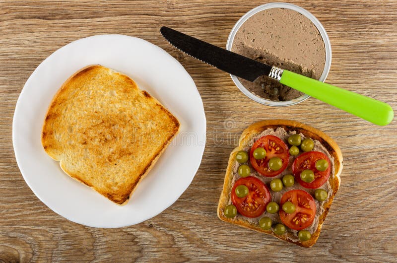 πιάτο με τοστ μαχαίρι στο βάζο με σάντουιτς με κρέας με κρέας με πράσινο μπιζέλια και ντομάτα στο τραπέζι. προβολή επάνω