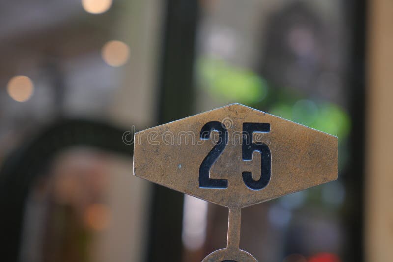 Πινακίδα με μεταλλικό αριθμό που δείχνει 25 σε πολυσύχναστο καφέ στοκ φωτογραφία με δικαίωμα ελεύθερης χρήσης