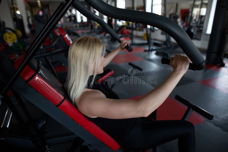 Πλάγια όψη μιας νέας φίλαθλης γυναίκας sportswear στη γυμναστική Το κορίτσι εκτελεί triceps τις ασκήσεις σε ένα στούντιο ικανότητ στοκ φωτογραφίες με δικαίωμα ελεύθερης χρήσης Πλάγια όψη μιας νέας φίλαθλης γυναίκας sportswear στη γυμναστική Το κορίτσι εκτελεί triceps τις ασκήσεις σε ένα στούντιο ικανότητ στοκ φωτογραφίες με δικαίωμα ελεύθερης χρήσης