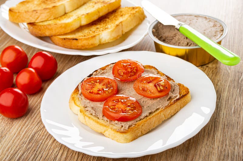 πλάκα με μαχαίρι τοστιού στο βάζο με ντομάτες από κρέας σάντουιτς με πέτσα κρέατος και κεράσι ντομάτας σε λευκή πλάκα σε ξύλινο τρ
