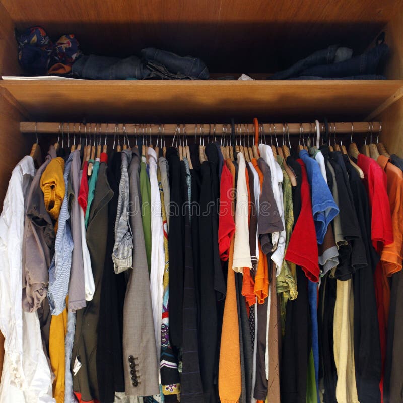 Crowded rack of clothes hanging in open wardrobe or closet. Crowded rack of clothes hanging in open wardrobe or closet.