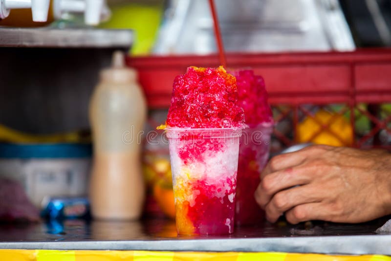 An street vendor in the city of Cali in Colombia preparing and selling a traditional sweet water ice called cholado. An street vendor in the city of Cali in Colombia preparing and selling a traditional sweet water ice called cholado