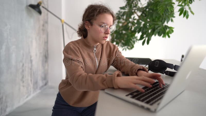 πλευρική άποψη σοβαρή έφηβα που εργάζεται με φορητό υπολογιστή σε χώρο συνεργασίας. συζήτηση κατ' οίκον με φίλους σε κοινωνικά θέμ