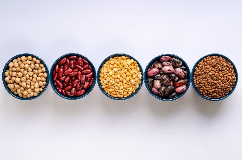Ποικίλα όσπρια Φακές, chickpeas, μπιζέλια και φασόλια στα μπλε κύπελλα σε ένα άσπρο υπόβαθρο r στοκ εικόνες Ποικίλα όσπρια Φακές, chickpeas, μπιζέλια και φασόλια στα μπλε κύπελλα σε ένα άσπρο υπόβαθρο r στοκ εικόνες