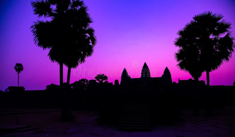 Sunrise Purple Palm trees ancient temple facade silhouette of the UNESCO Angkor Wat temple in Angkor Archaeological Park near Siem Reap in Cambodia. Sunrise Purple Palm trees ancient temple facade silhouette of the UNESCO Angkor Wat temple in Angkor Archaeological Park near Siem Reap in Cambodia.