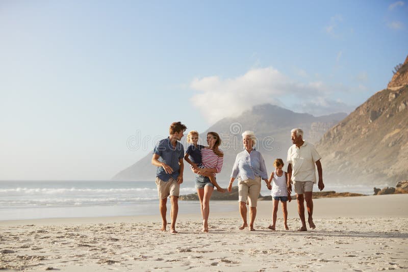 Πολυ οικογένεια παραγωγής στις διακοπές που περπατά κατά μήκος της παραλίας από κοινού