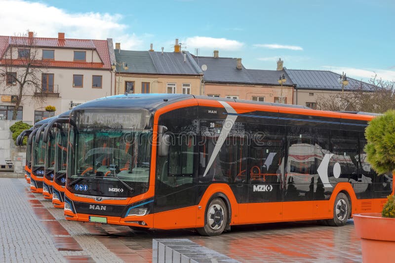 New city buses with electric and hybrid drive ("environmentally friendly" technology) standing among the historic buildings on the granite surface of the historic city square just after the rain . New city buses with electric and hybrid drive ("environmentally friendly" technology) standing among the historic buildings on the granite surface of the historic city square just after the rain .