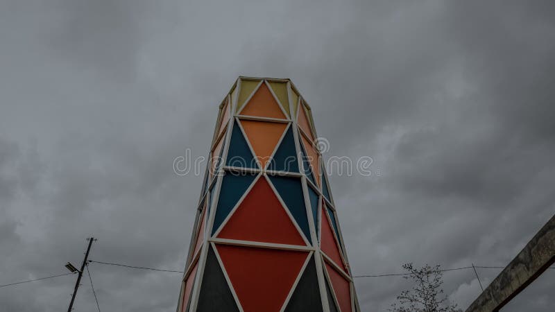 πολύχρωμα γεωμετρικά τριγωνικά μοτίβα πύργου με θολό ουρανό στοκ εικόνες