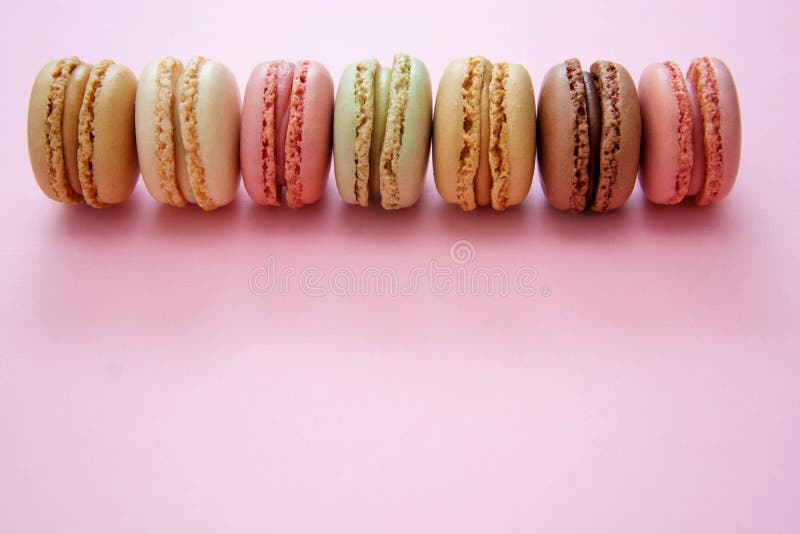 πολύχρωμα παραδοσιακά γαλλικά macaroons cookies πάνω από ροζ φόντο με διάστημα αντιγραφής. πολύχρωμα παραδοσιακά γαλλικά macaroons cookies σε ροζ φόντο με χώρο αντιγραφής για κείμενο