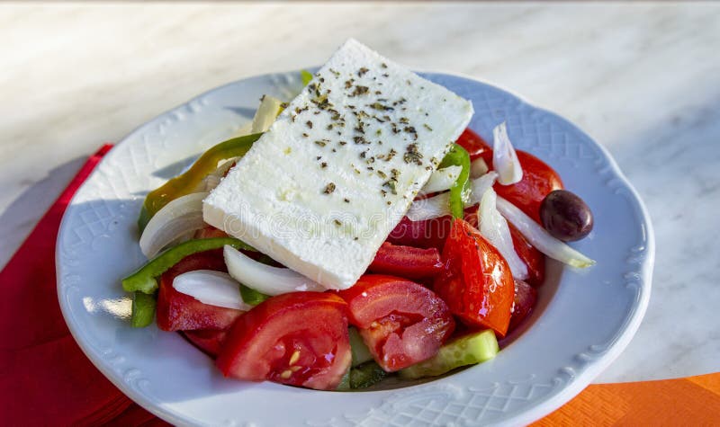 πολύχρωμη ελληνική σαλάτα με ένα μεγάλο κομμάτι φέτα φέτα στοκ εικόνα