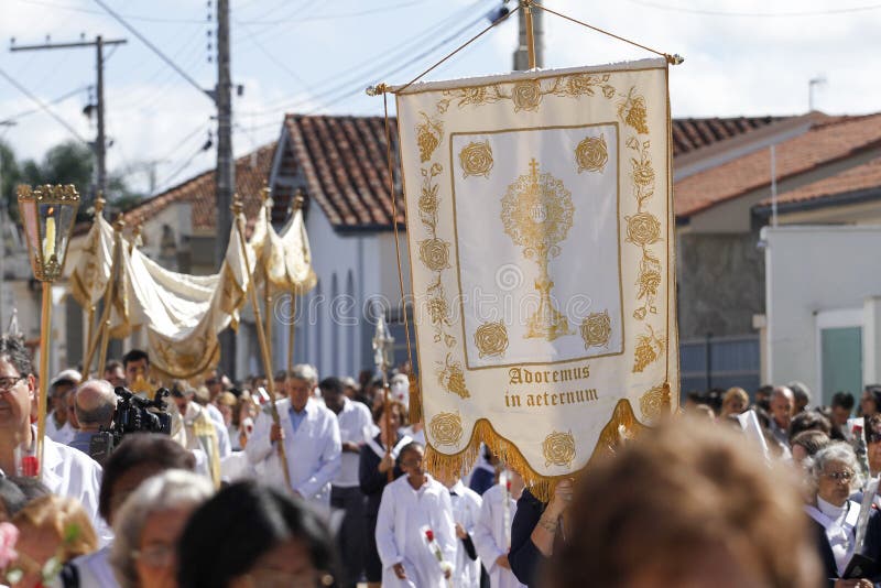 OLIVEIRA, MG / BRAZIL - 2015-06-04: Catholic faithful accompany monsignor containing the Blessed Sacrament during a Corpus Christi procession in Minas Gerais. OLIVEIRA, MG / BRAZIL - 2015-06-04: Catholic faithful accompany monsignor containing the Blessed Sacrament during a Corpus Christi procession in Minas Gerais