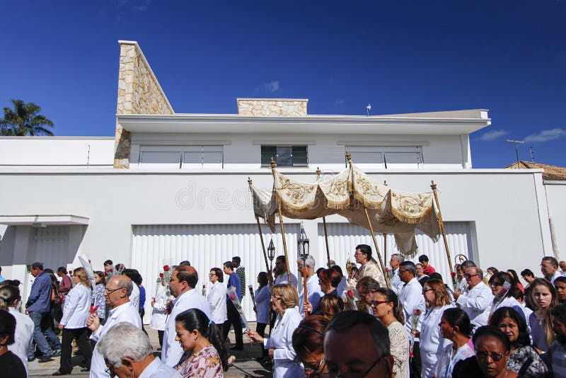 OLIVEIRA, MG / BRAZIL - 2015-06-04: Catholic faithful accompany monsignor containing the Blessed Sacrament during a Corpus Christi procession in Minas Gerais. OLIVEIRA, MG / BRAZIL - 2015-06-04: Catholic faithful accompany monsignor containing the Blessed Sacrament during a Corpus Christi procession in Minas Gerais