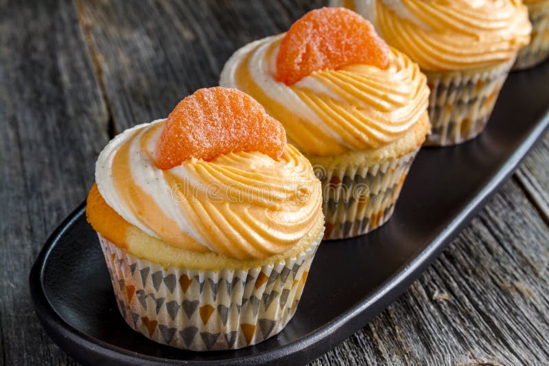 Πορτοκαλί φασόλι βανίλιας στροβιλισμένο Cupcakes στοκ εικόνα Πορτοκαλί φασόλι βανίλιας στροβιλισμένο Cupcakes στοκ εικόνα